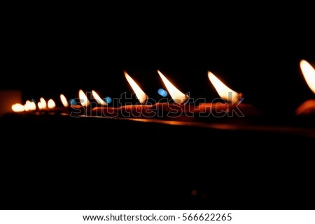 many candles brightly against a black background

