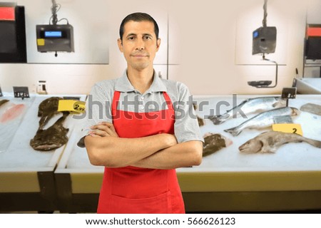 fishmonger smiling and looking at camera arms crossed