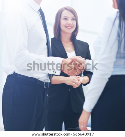Happy business partners shaking hands in an office