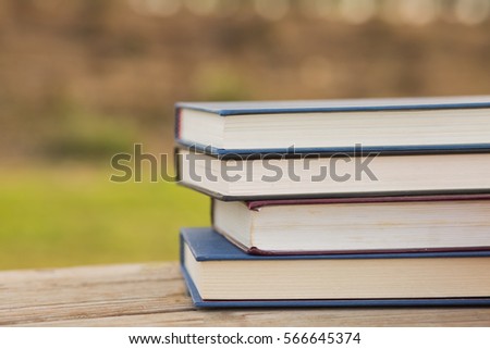 Pile of closed books on wooden background.