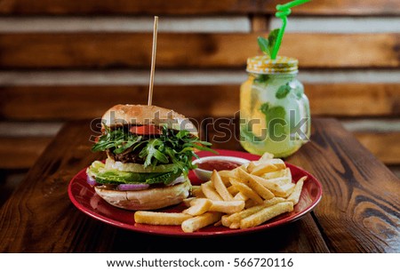 Big cheeseburger and chips on a plate. Restaurant