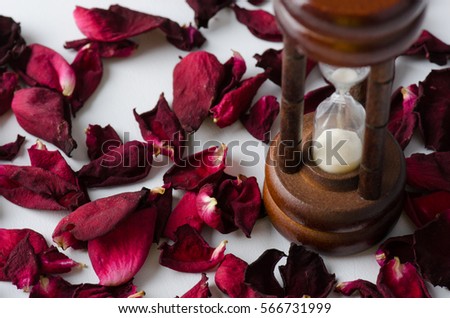 Dried rose petal with sandglass. Time is runing out.