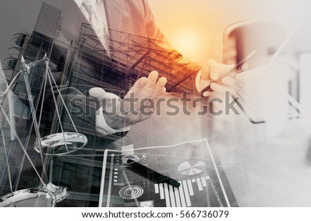 double exposure of justice and law concept.Male lawyer in office with the gavel,working with smart phone,digital tablet computer docking keyboard,brass scale,on wood table,London architecture city