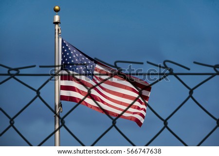 American flag and de-focused fence, the United States confrontation and refugees
