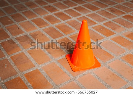 The orange traffic cone on street , traffic sign , concrete road
