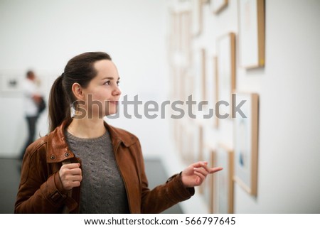 Portrait of positive adult brunette girl in art museum