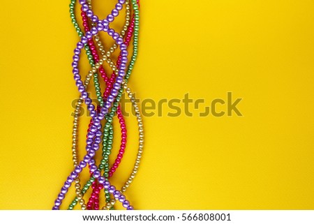 Multi color Mardi Gras beads on paper background. Top view