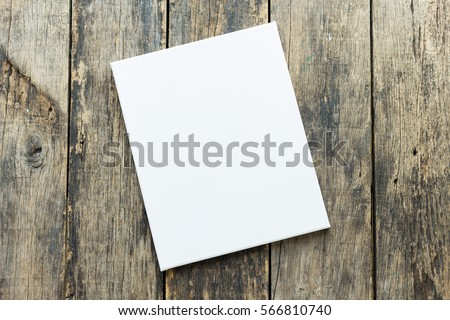 Empty white canvas frame on a wooden background.
