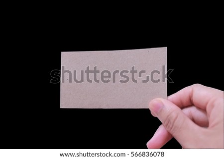 Hand holding a blank brown business card isolated on black with copy space for your trade, profession, brand, contact details and credentials .This has clipping path.