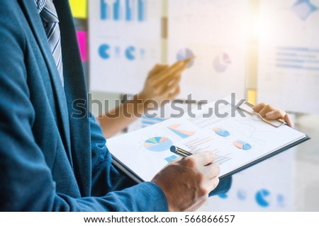 hands of businessman reading data paper while business woman pointing paper background, business concept