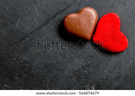 Chocolate hearts candies on black background Top view Copy space Valentines day postcard concept