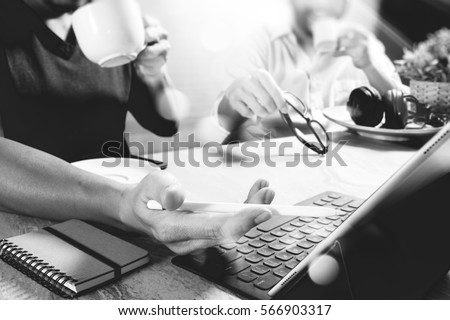co working website designers working at office and holding a cup of coffee,working on smart phone and digital tablet computer docking on smart keyboard,black white        