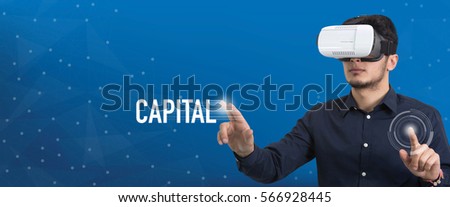Future Technology and Business Concept: The Man with Glasses of Virtual Reality and touching CAPITAL button