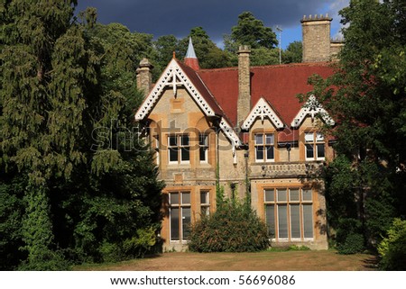 A rather dramatic image of a large period family home surrounded by woodland