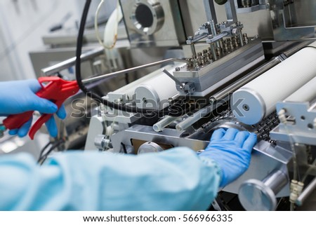 close picture ofworker fixing the machine with shafts