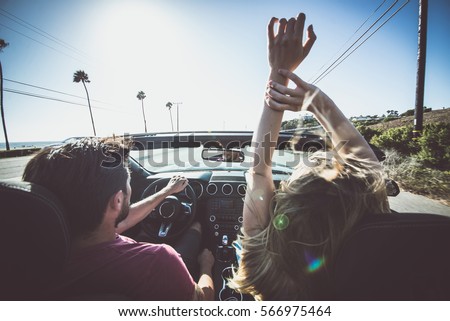 Couple driving on a convertible car Royalty-Free Stock Photo #566975464