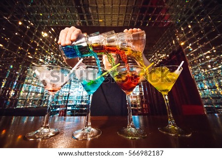 Barman show. Bartender pours alcoholic cocktails. Royalty-Free Stock Photo #566982187