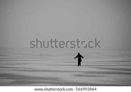 Silhouette of a man ice skating on a frozen lake fairy tale mystery nature background 