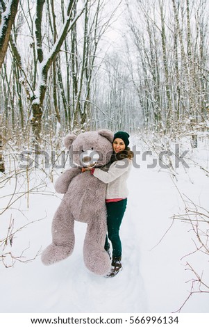 cute young girl with big teddybear winter woods