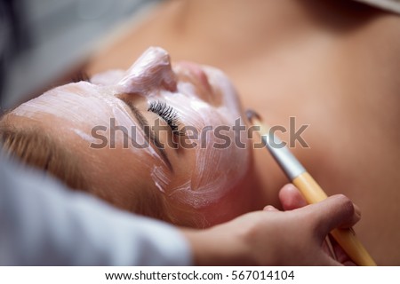 Beautiful young woman having a facial cosmetic treatment. Royalty-Free Stock Photo #567014104