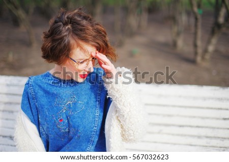 girl sitting on a bench face exposed to the sun