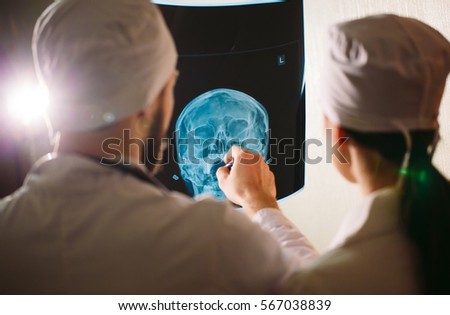 Doctors watching x-ray of patient.