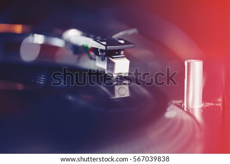 Turntables needle on vinyl record. DJ turn table player playing music in high fidelity. Professional audio equipment in closeup. Listen to the musical tracks on hi fi system in sound recording studio