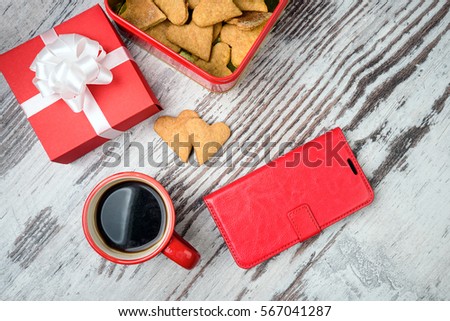 two red coffee cup, hearts cookies and gift box on wooden surface. Valentines day concept.