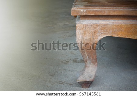 Decorative carving table leg. on a wooden floor. furniture in classic style. white tree with gold trim. patina. carving. small depth of field. luxury furniture.