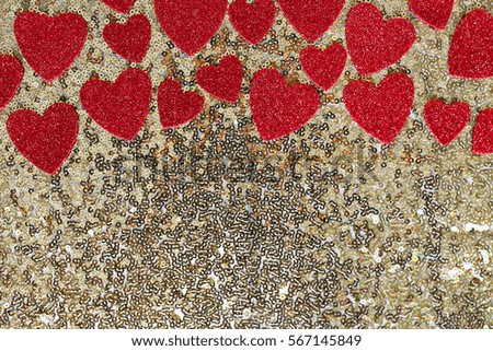 Red Sparkly heart confetti is framing the top border of a gold sequin background, with room for copy-space.