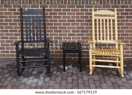 Black and tan chairs on brick patio against brick wall.