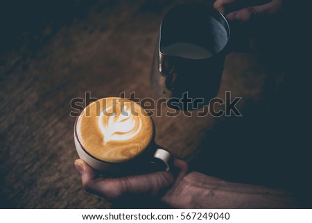 Barista pours milk making cappuccino or latte. Toned picture