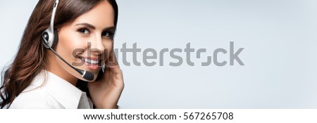 customer support phone operator in headset, with blank copyspace area for slogan or text message, over grey background. Consulting and assistance service call center. Royalty-Free Stock Photo #567265708