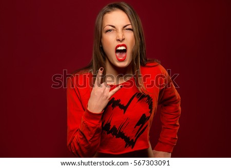 close-up of a girl opened his mouth wide and showing thumbs up sign rock on a red background