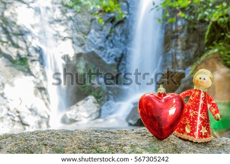 red heart on the rock in waterfall