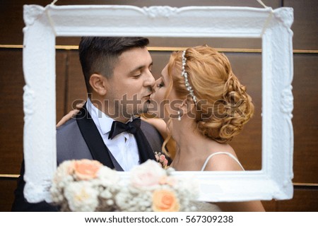 groom and bride posing in a white frame