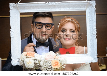groom and bride posing in a white frame