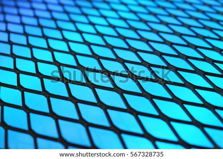 Abstract parallelograms structure with shallow dof. Blue background with dark metal mesh. Technology concept.