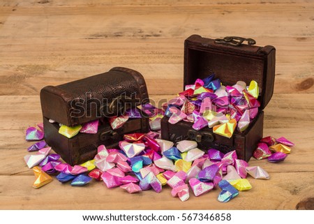 Ancient treasure chest filled heart with a wooden background