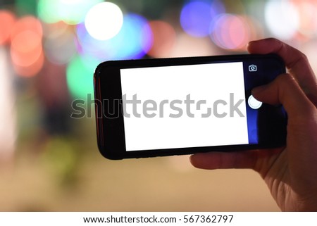 woman hand holding smartphone blank screen for take photo with night light bokeh.