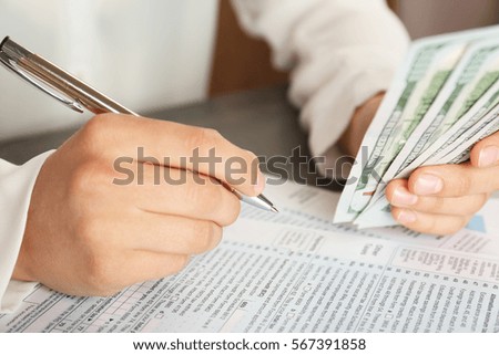 Woman filling individual income tax return form, closeup