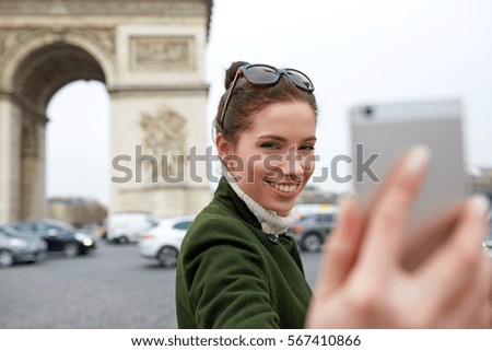 young woman visiting Paris. Triumphal arch. make selfie