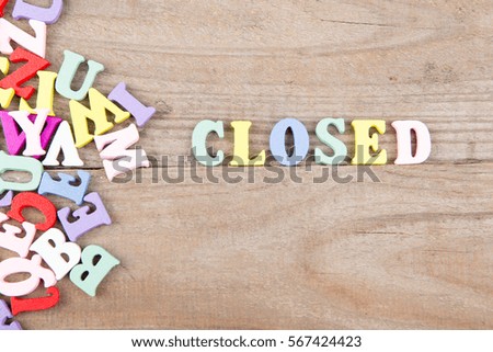 Text "Closed" of colored wooden letters on a wooden background