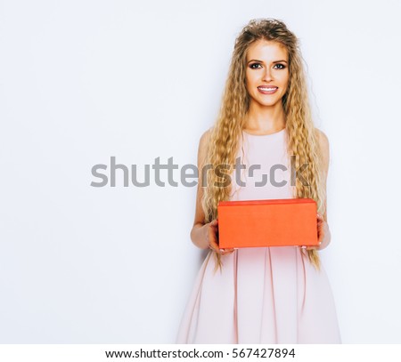 Love sign. Beauty stylish blonde woman posing in fashionable clothes, making heart sign, symbol with hands white wall background. Positive emotion expression feeling life perception. Valentine's Day.