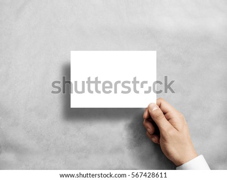 Hand holding blank white postcard flyer mockup. 6 x 4 leaflet mock up presentation. Postal holder. Man show clear post card paper. Sheet template. Invitation booklet reading first person view Royalty-Free Stock Photo #567428611