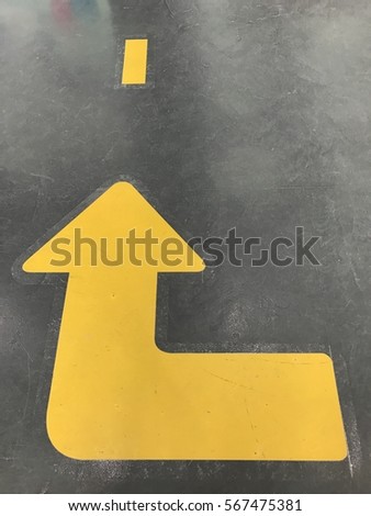 Yellow arrow sign on the road