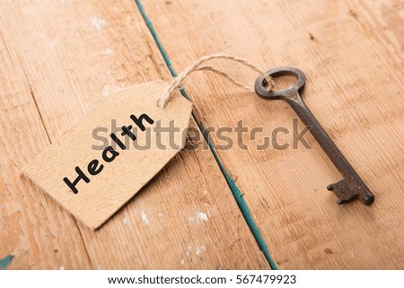 Old rusty key with a paper label on the wooden board