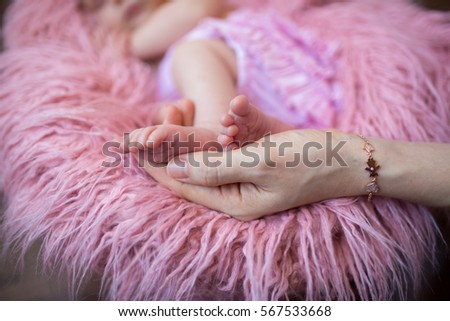 mother holding small baby legs