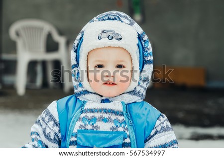 Charming baby in a blue coat posing in grandmother