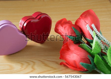 Red roses and heart on wood background